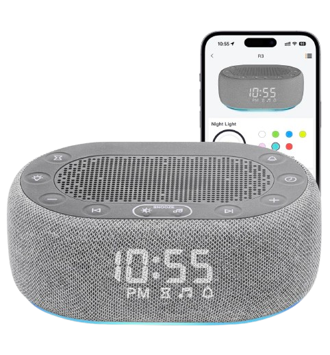 Gray fabric-covered white noise machine with digital clock display reading 10:55 PM, illuminated base light, and smartphone app shown behind it for sound and light controls.
