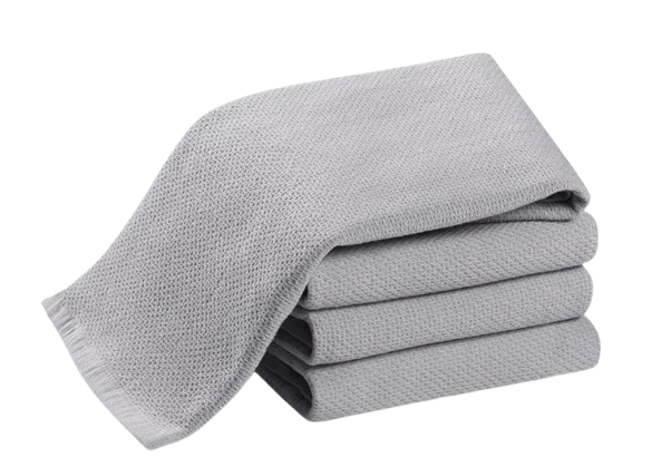 Set of four folded light gray waffle-weave cotton kitchen towels with textured pattern and finished hems.