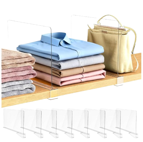 Clear acrylic shelf dividers clipped onto a wooden closet shelf, separating neatly folded shirts, sweaters, and handbags into tidy vertical sections.