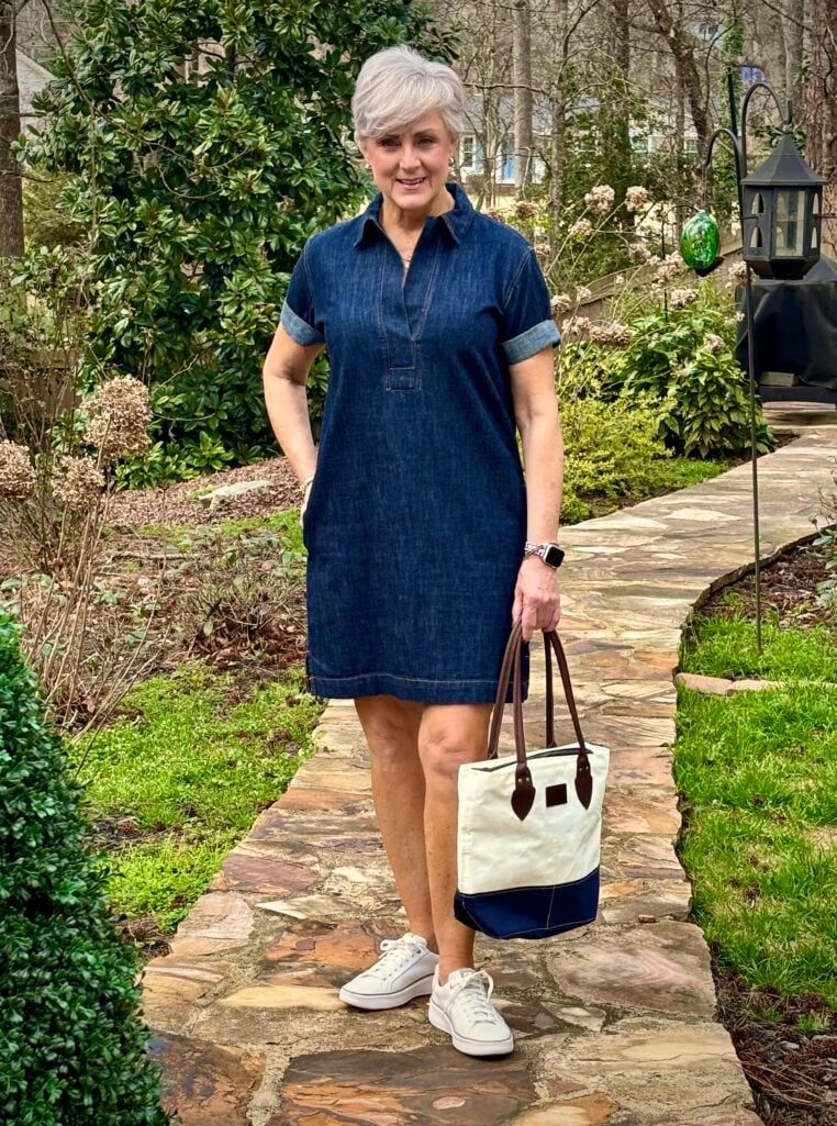 Woman over 50 wearing dark rinse denim polo dress with white sneakers — casual spring dresses after 50