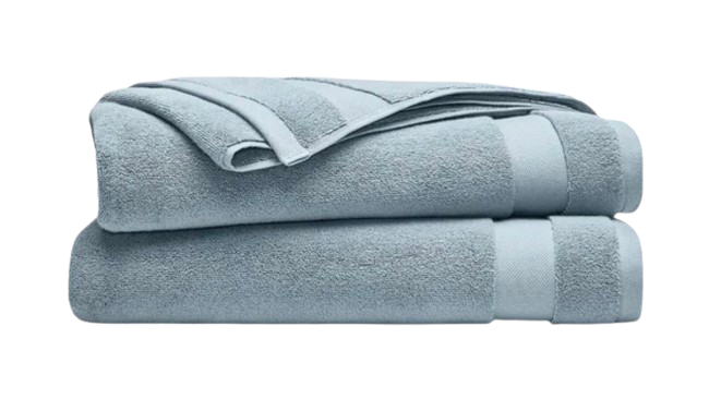 Stack of Brooklinen super-plush bath towels in soft light blue, featuring thick, ultra-absorbent cotton with a dense, spa-like texture and neatly finished edges.