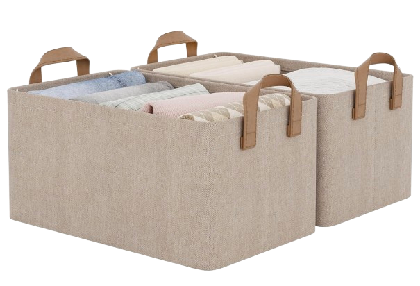 Set of neutral beige fabric storage bins with structured sides and brown faux leather handles, filled with folded clothing and linens for organized closet storage.