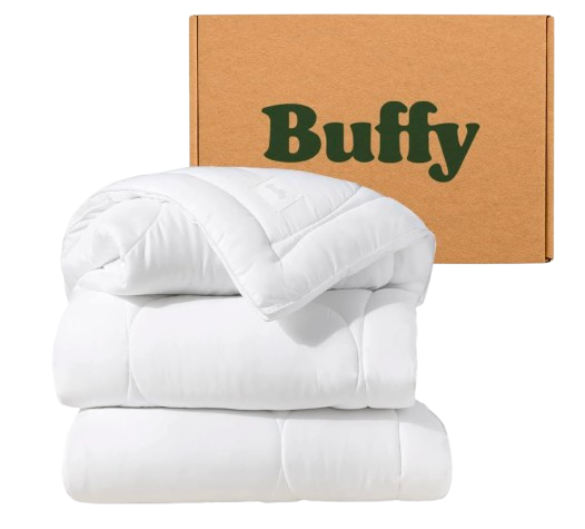Buffy Cloud queen comforter in bright white, featuring a fluffy, quilted design with soft, lightweight fill, styled folded in front of branded packaging box.