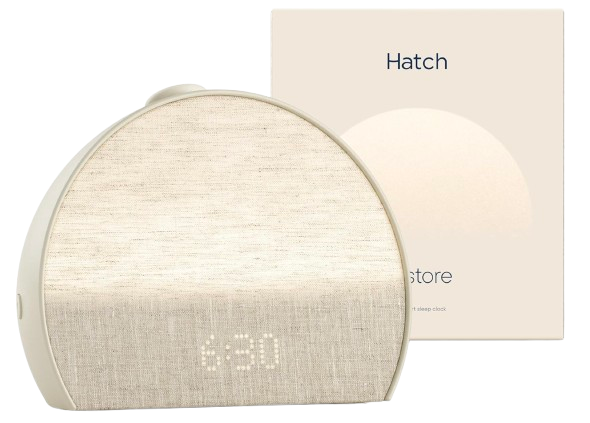 Hatch Restore 3 sunrise alarm clock with a rounded, fabric-covered front in a neutral beige tone, displaying a soft digital time and designed to simulate natural light for gentle wake-ups.