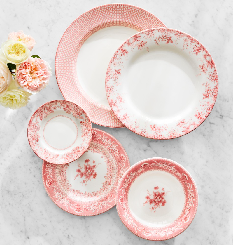 Pink and white English floral dinnerware set with delicate vintage-inspired patterns, including layered plates and bowls with intricate botanical detailing.