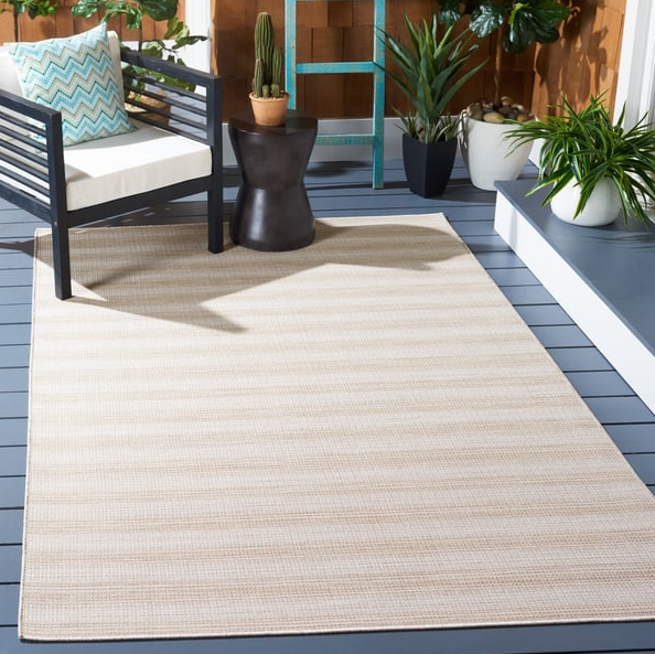 Neutral striped outdoor rug in a 4x6 size, styled on a patio with modern seating and potted plants for a clean, coastal-inspired look.