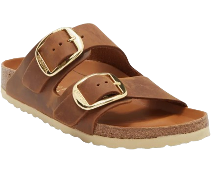 Brown leather Birkenstock slide sandal with two adjustable straps, oversized gold buckles, a contoured cork footbed, and a lightweight sole.
