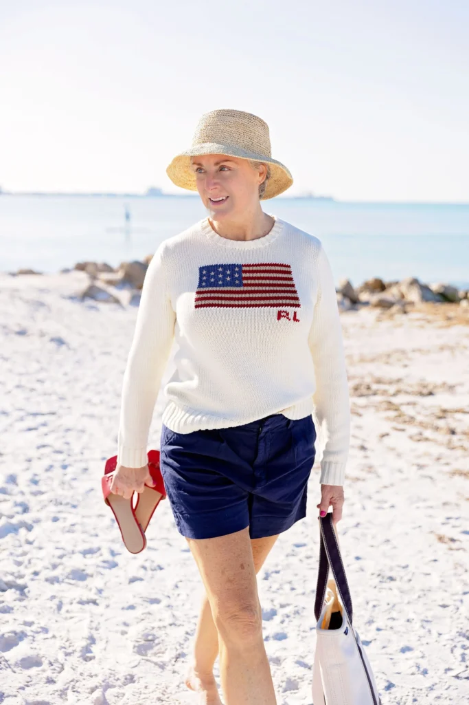 Ralph Lauren flag sweater styled with navy linen shorts and raffia bucket hat for classic Americana fashion over 50
