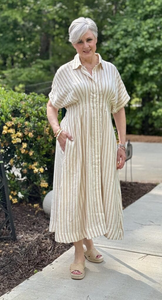 Beth wearing a tan and cream striped linen shirtdress with espadrille wedge sandals]
