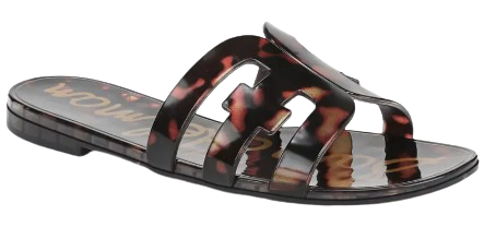Tortoiseshell jelly slide sandal with oversized cutout logo straps and a flat silhouette, offering a chic, water-friendly style.