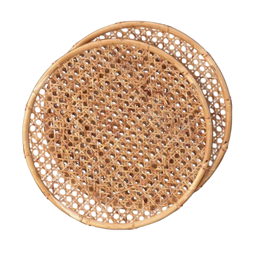 Set of two round rattan charger plates with an intricate woven cane pattern and natural honey-brown finish, perfect for layering under dinnerware for casual summer entertaining.