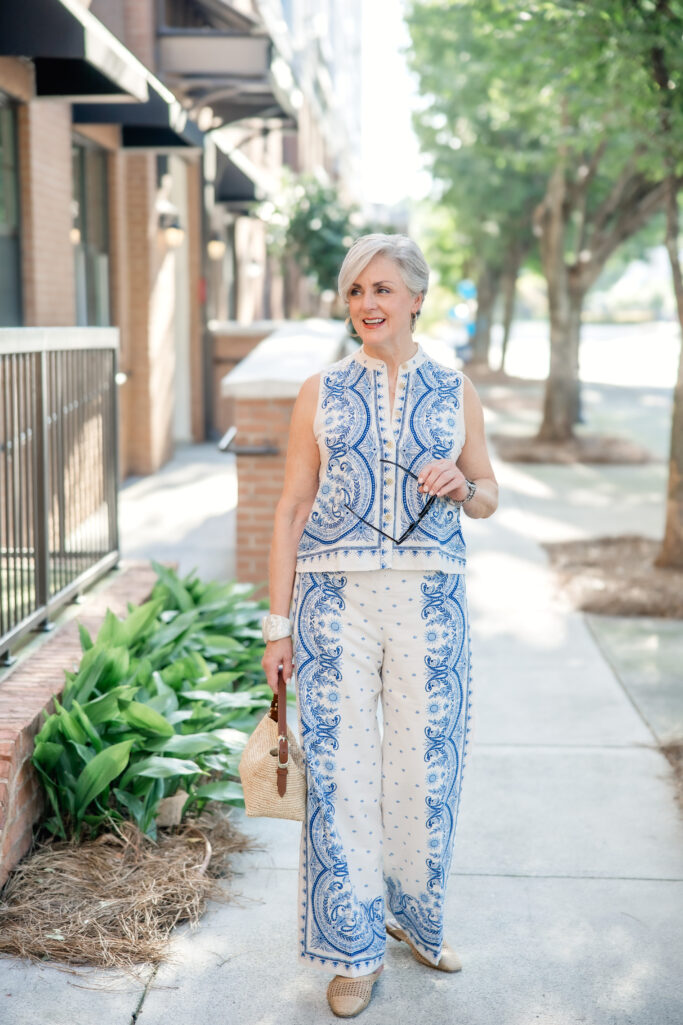Blue and white paisley sleeveless shirt and matching wide-leg pants with raffia bag