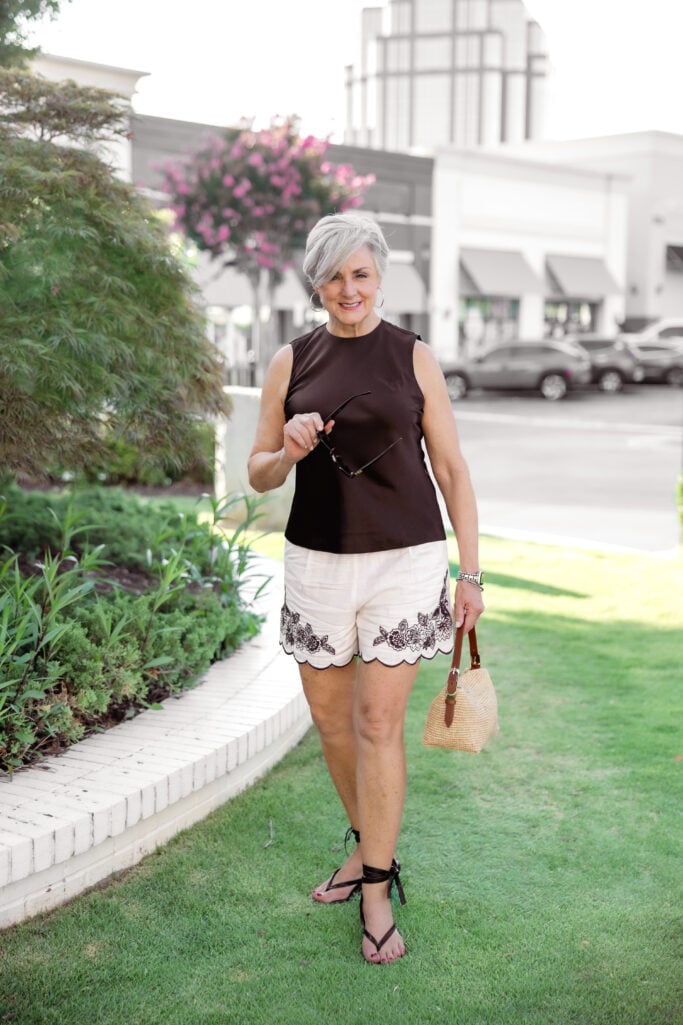  Beth Djalali of Style at a Certain Age in a brown sleeveless top and embroidered scalloped shorts at the start of her high school reunion glow up