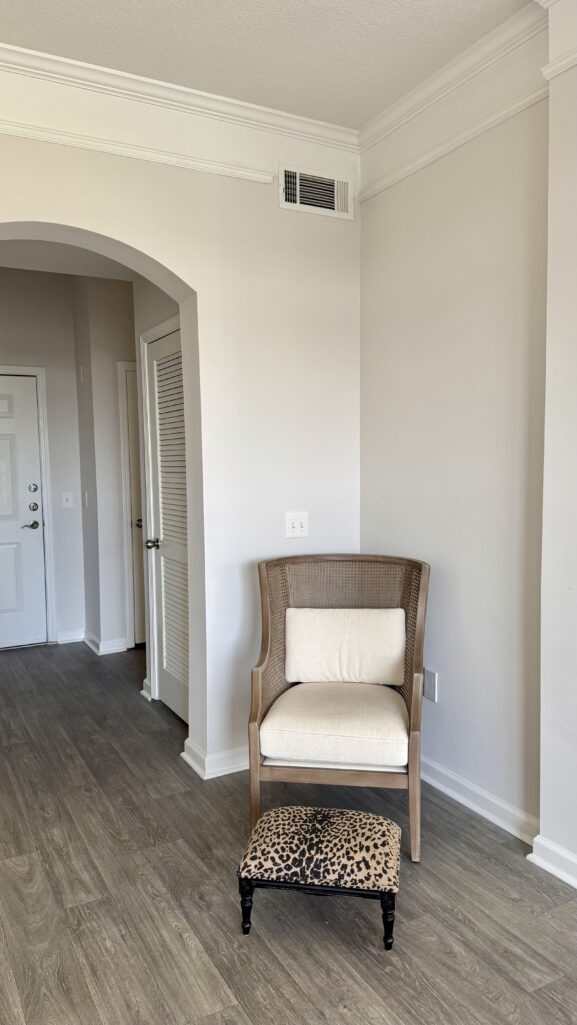 Cane accent chair and matching ottoman from Ballard Designs styled in an American Classic apartment living room