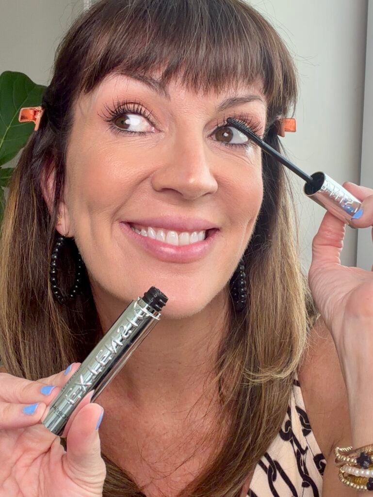 Applying curling and lengthening mascara for defined lashes.