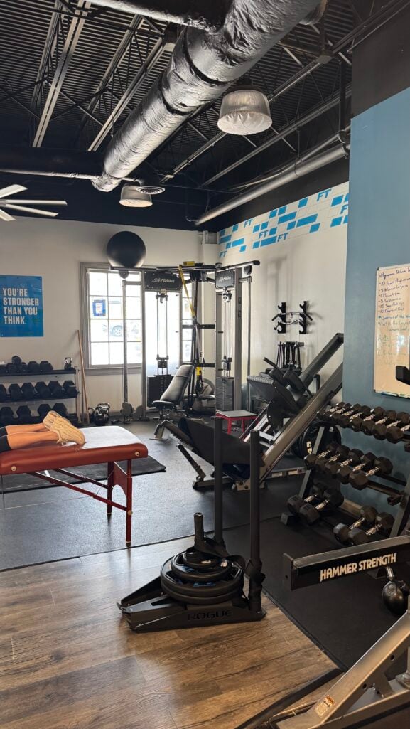 Interior of the Fitness Together Dunwoody gym showing dumbbell racks and strength training equipment